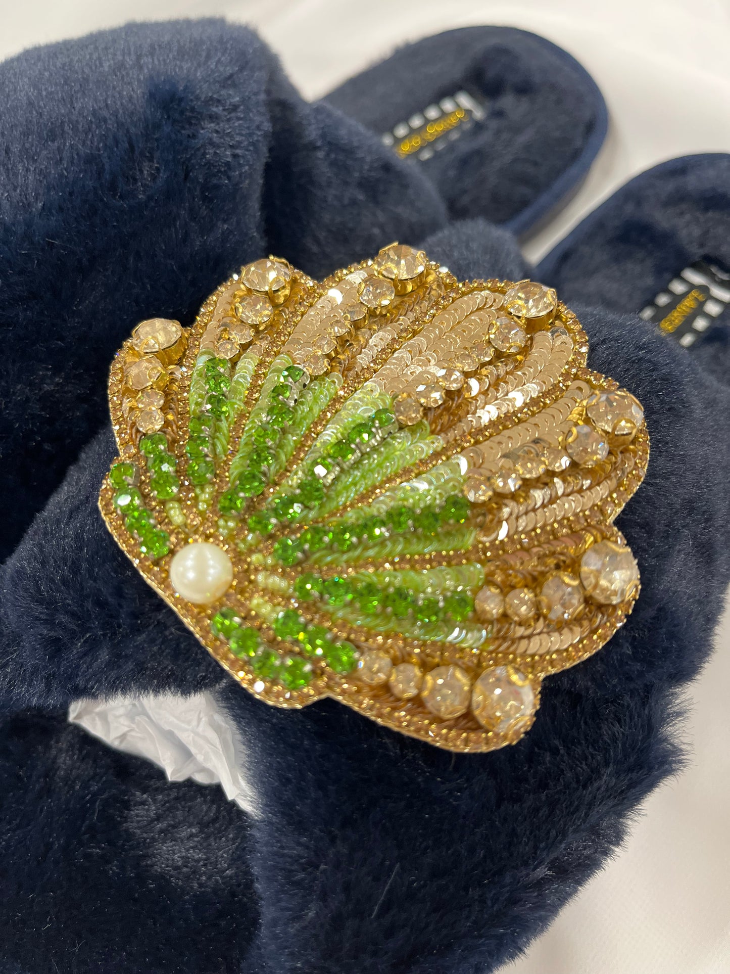 Laines London navy fluffy slippers with green and gold seashell brooch